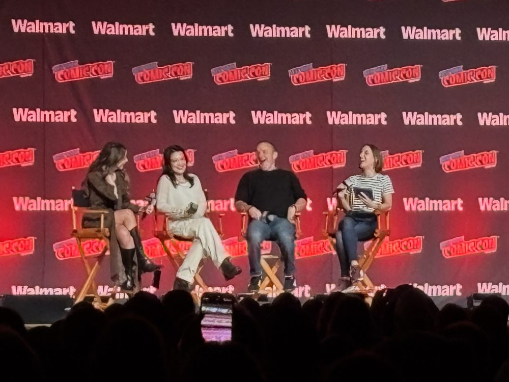Agents of S.H.I.E.L.D. reunion panel at NYCC 2025 featuring Chloe Bennet, Ming-Na Wen, Clark Gregg, and moderator Ashley V. Robinson onstage at the Javits Center.